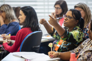 Sala de aula da formação do Diversa Presencial, destacando aluna que faz um comentário