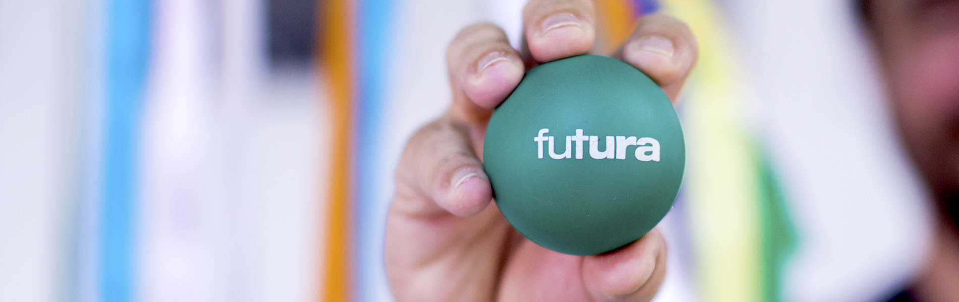 Imagem de mão segurando uma bola verde com a logomarca do Canal Futura.