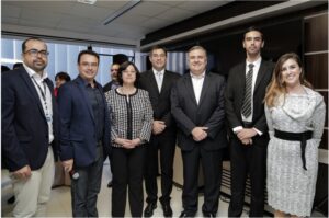Foto de cinco homens e duas mulheres em pé, lado a lado, posando para a foto.