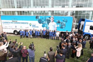 Foto do caminhão do projeto Carretas do Conhecimento do lado de fora do Palácio do Iguaçu, sede do governo paranaense, sendo apresentado para a imprensa.