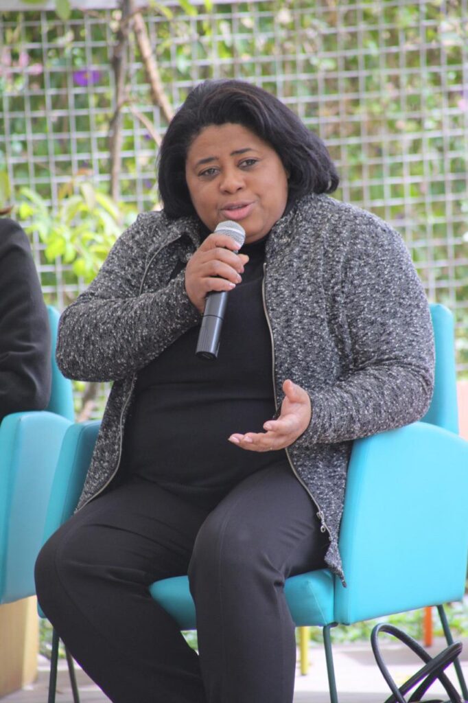 Foto de uma mulher negra falando ao microfone