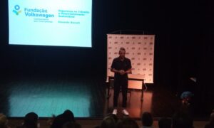 Foto de um homem em pé em um palco.