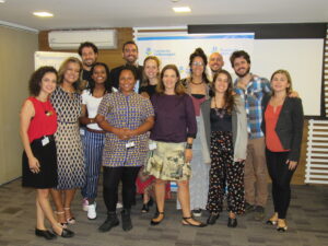 Foto de um grupo de pessoas em pé e sorrindo para a câmera