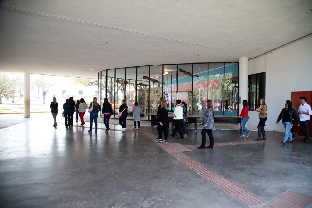 Foto de um grupo de pessoas na marquise do Parque Ibirapuera em frente ao Museu de Arte Moderna (MAM)